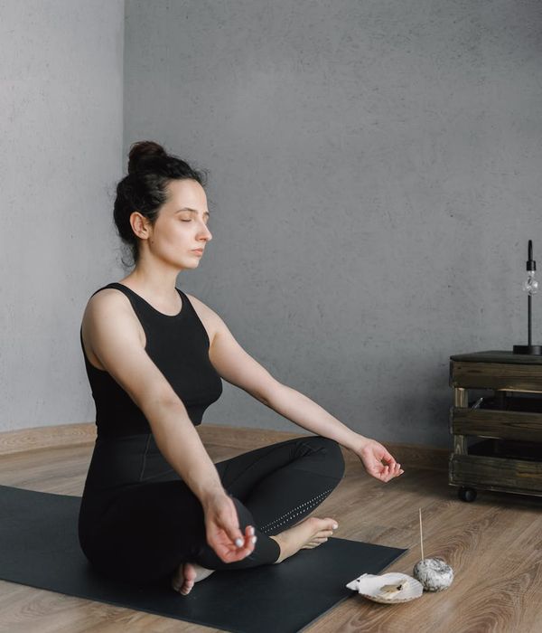 Person meditating peacefully in a brightly lit room with minimalist decor.
